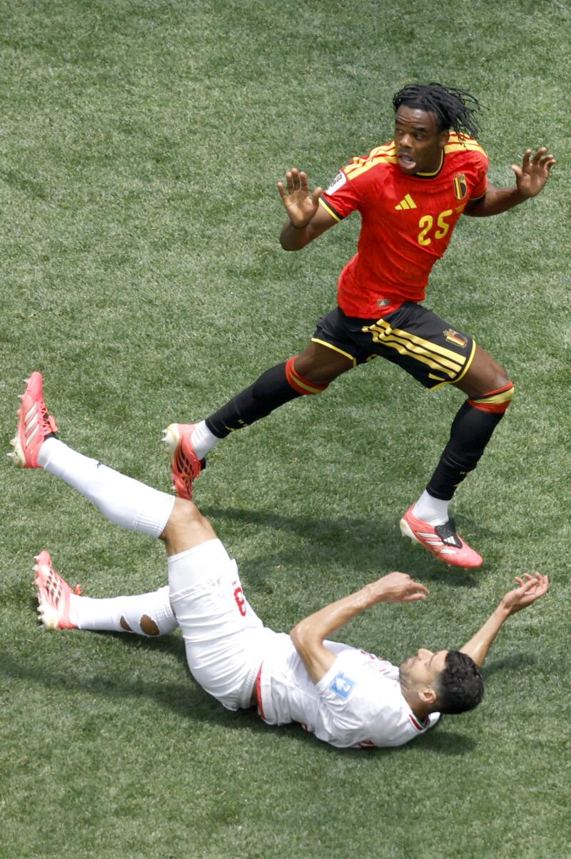 Belgium defender Nathan Ngoy fouls Iran forward Mehdi Taremi.
