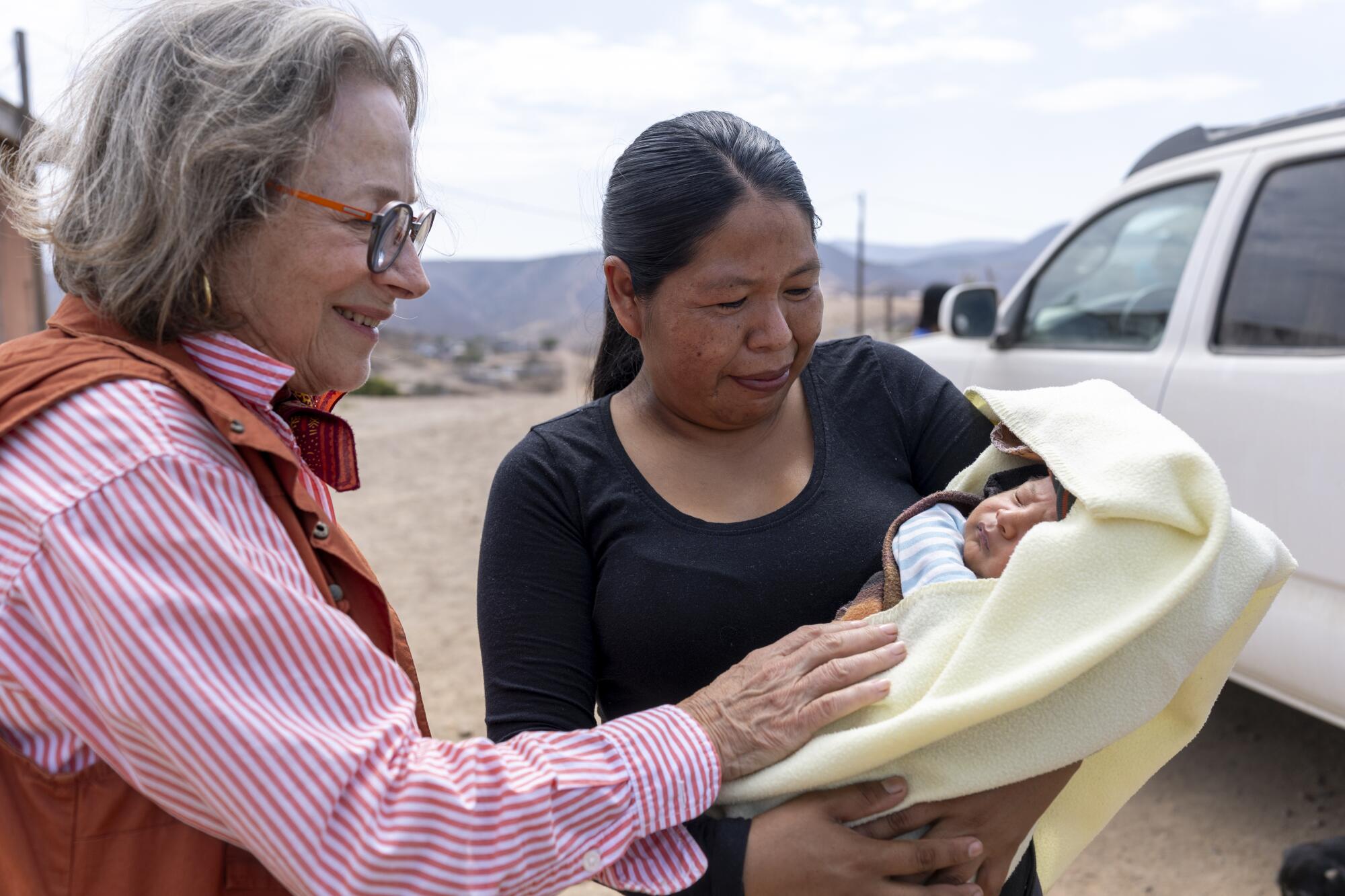 Nancy Ganechau, left, is shown 26-day-old Ricardo by his mother Christina