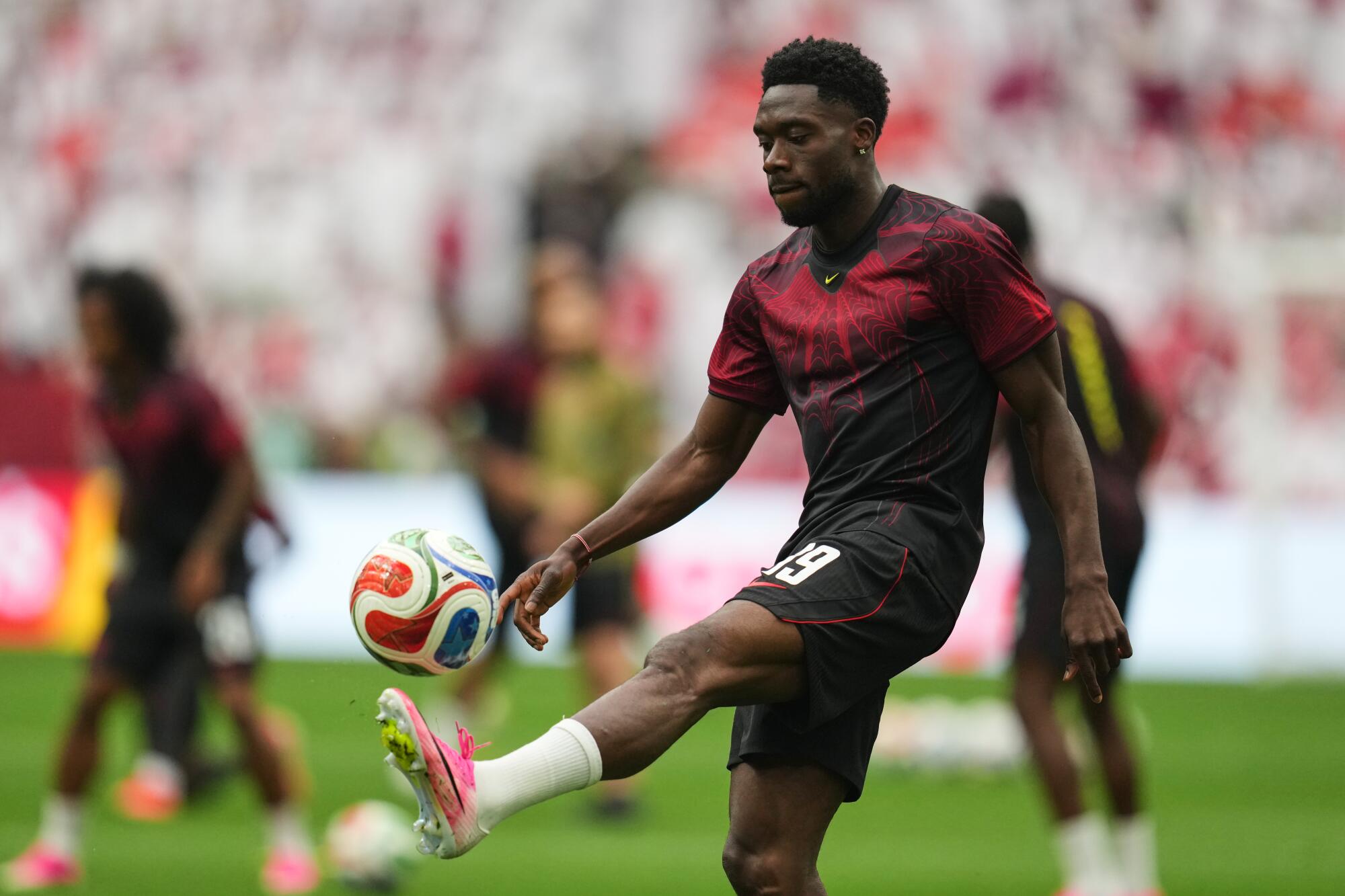 Canada's Alphonso Davies warms up before a World Cup match against Qatar on June 18.