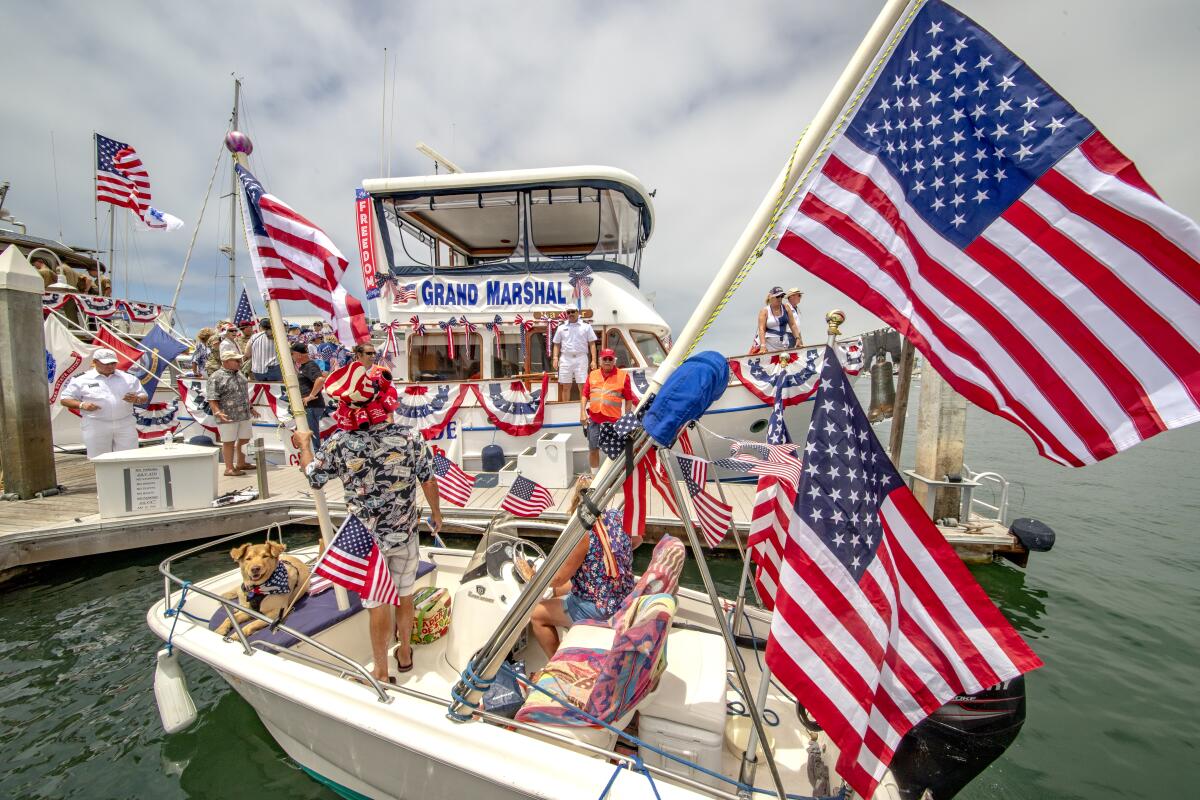 A passing skiff stops by the Grand Marshal boat for a brief social call before casting off for Newport Harbor.