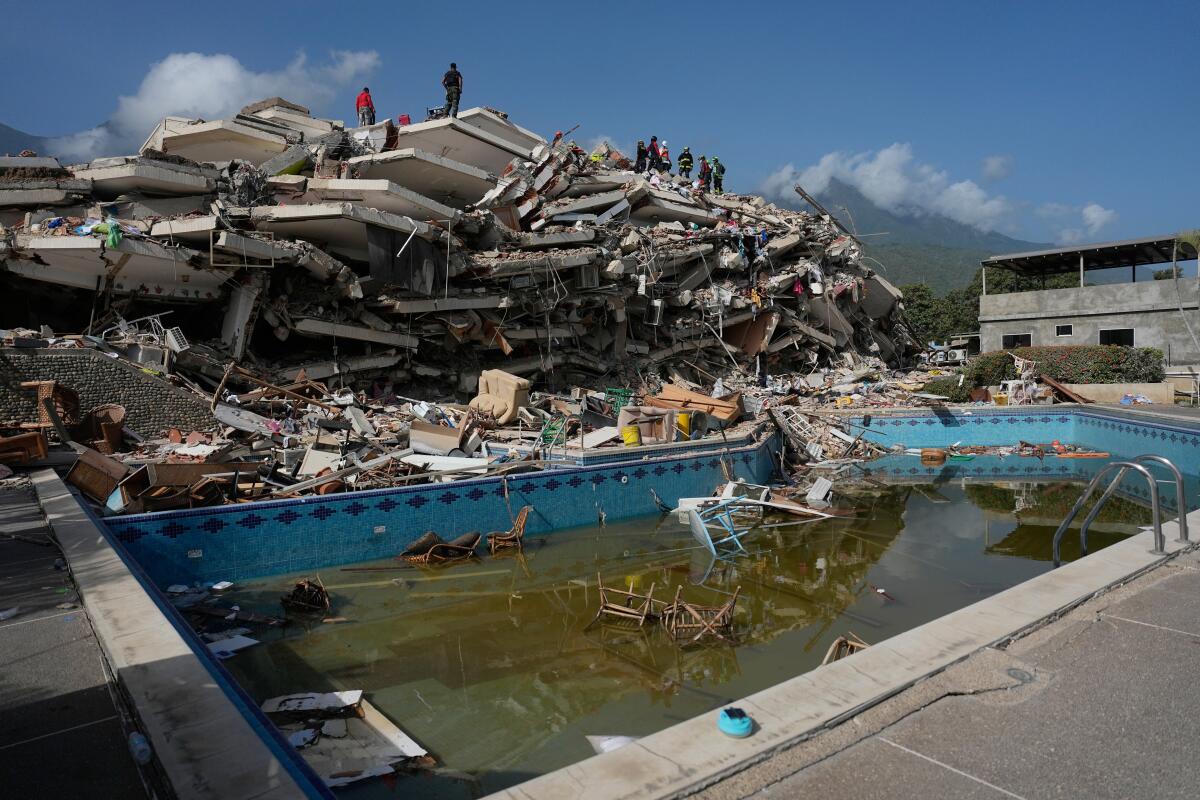 Rescue workers search through rubble on Saturday in Catia La Mar following the devastating double earthquakes.