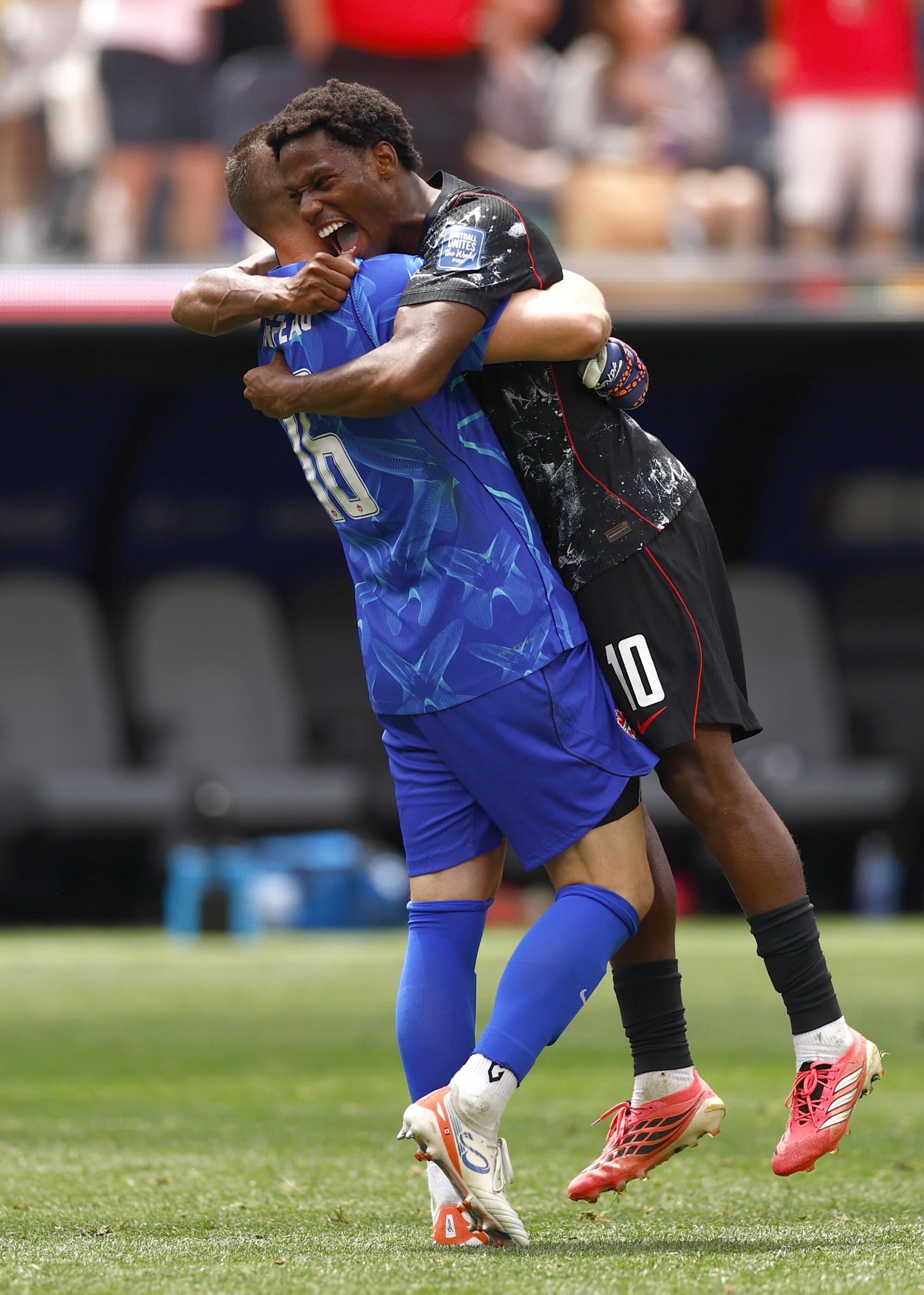 Canada goalkeeper Maxime Crepeau (16), left, celebrates with teammate Jonathan David after a 1-0 win.