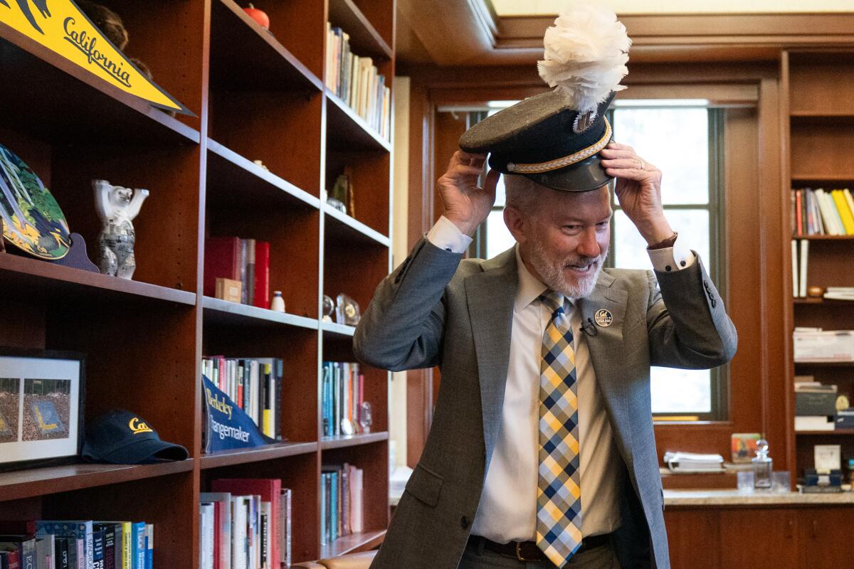 UC Chancellor Rich Lyons puts on a band hat.