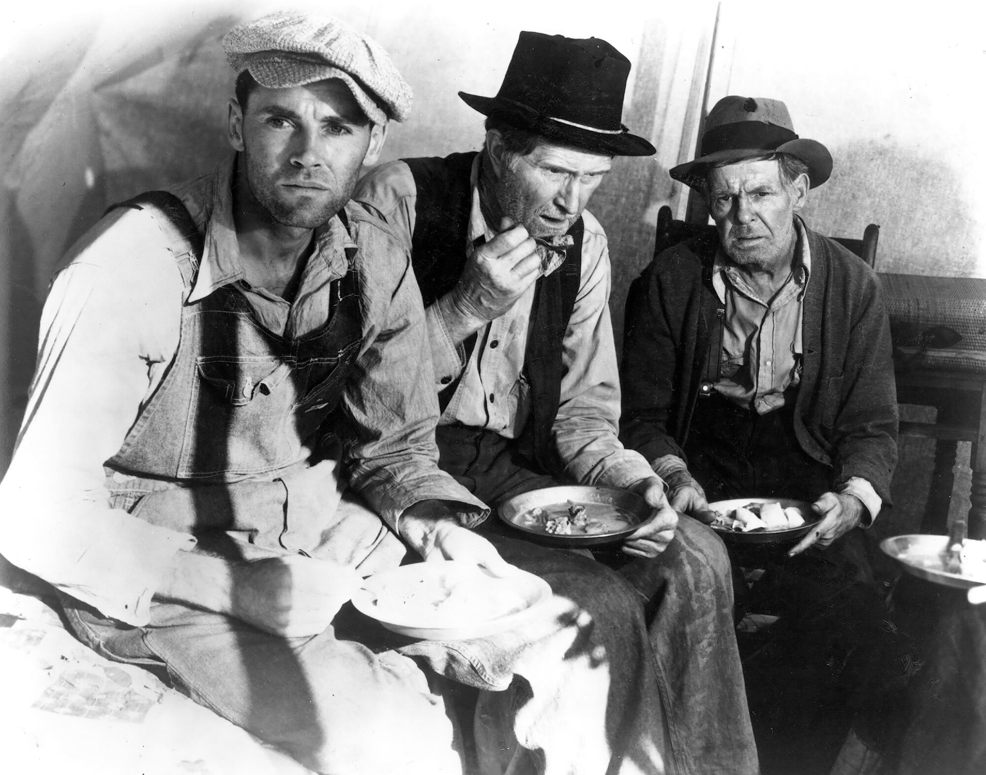 Oklahoma farmers on the trail westward share a meal.
