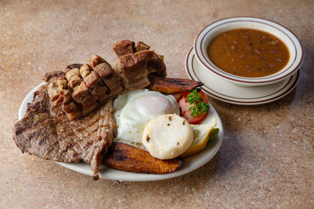 Carne asada, chorizo and chicharron accompanied by rice, beans, maduro, a fried egg and an arepa