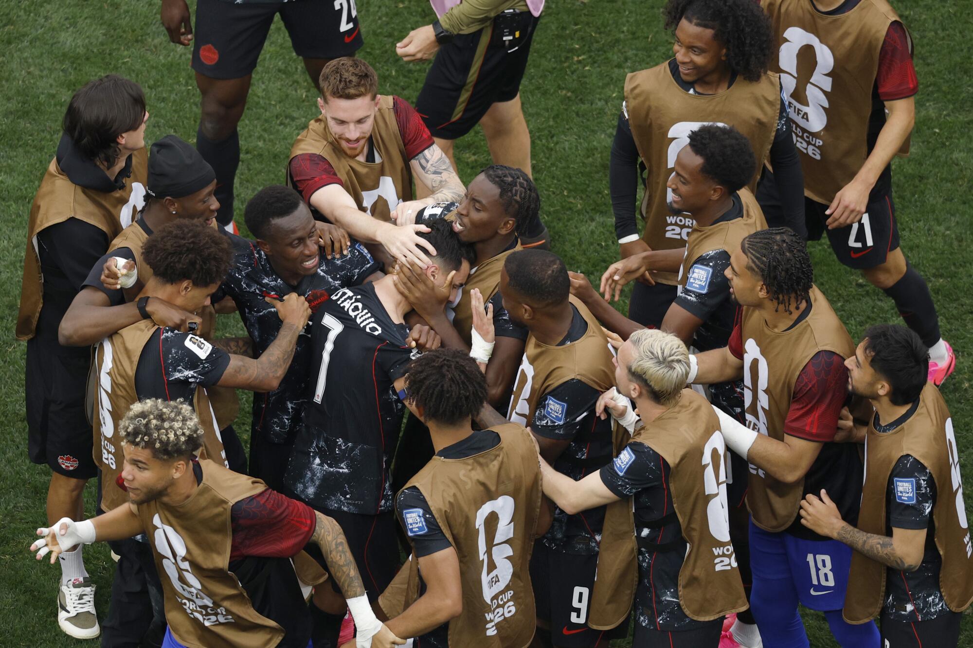 Canada midfielder Stephen Eustáquio (7) celebrates with teammates after scoring in the 92nd minute.