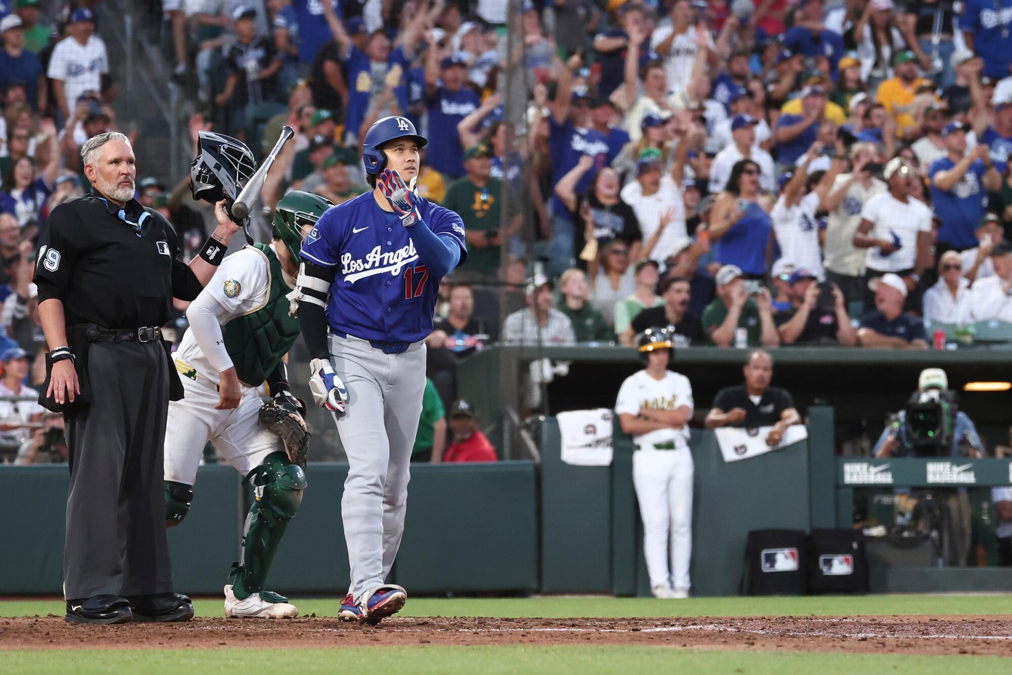 Shohei Ohtani tosses his bat after hitting a three-run home run for the Dodgers.