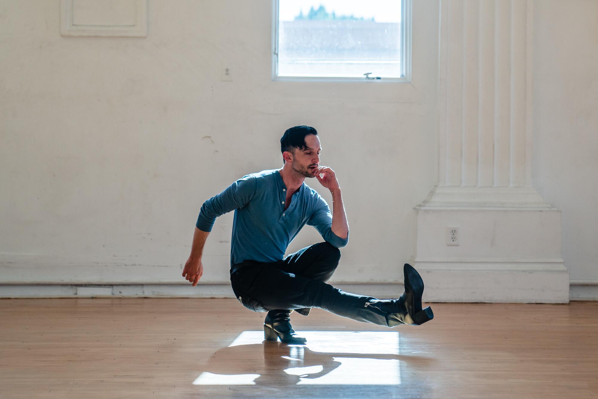 Andrew Pearson balances on one foot in the studio. 