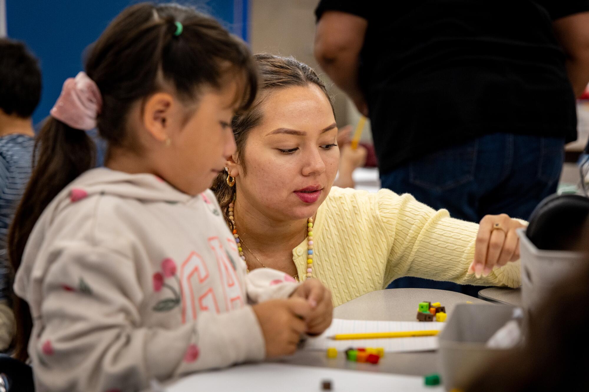 Classroom assistant teacher Daniella Zelaya helping a student with their math at Laurel Street Elementary in Compton