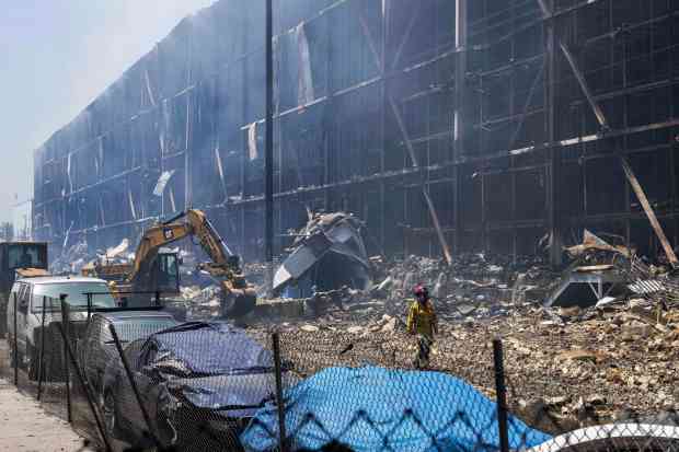 LAFD Captain Justin Horwedel walks past the smouldering remains of a massive cold storage facility fire in Boyle Heights on Tuesday, June 23, 2026. (Photo by Drew A. Kelley, Press-Telegram/SCNG)