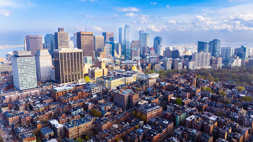 Orange brick houses along stunning skyscrapers. Varied scenery of Boston, Massachusetts, USA. Aerial view.