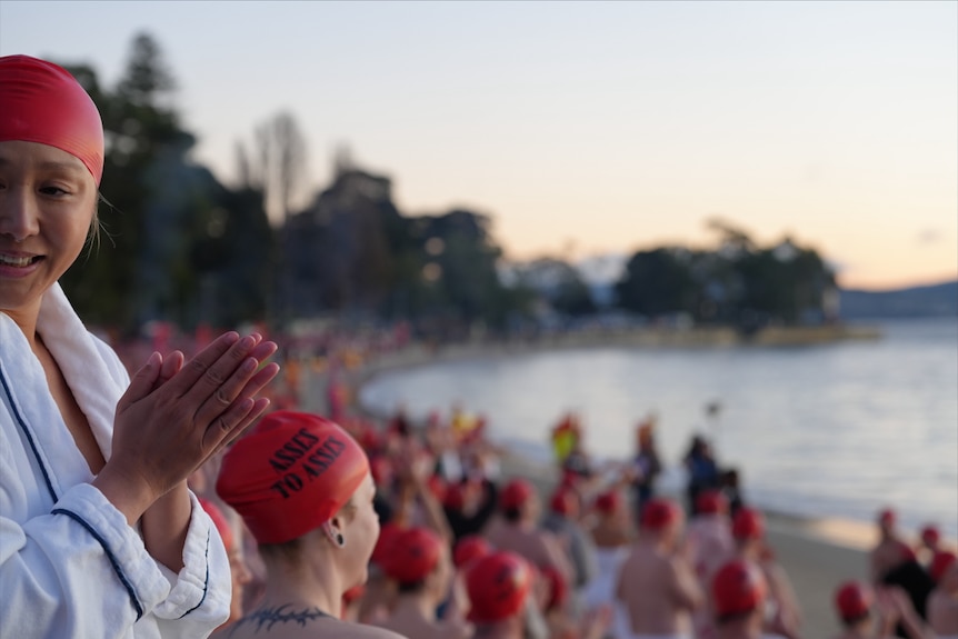 Crowd of swimmers prepare to enter the water for Dark Mofo's 2026 Nude Solstice Swim