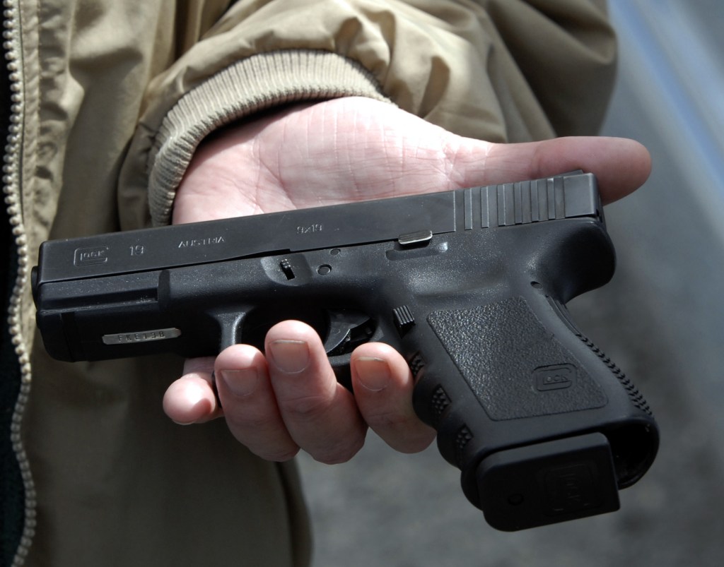 John Markell holds a Glock 9 mm pistol.