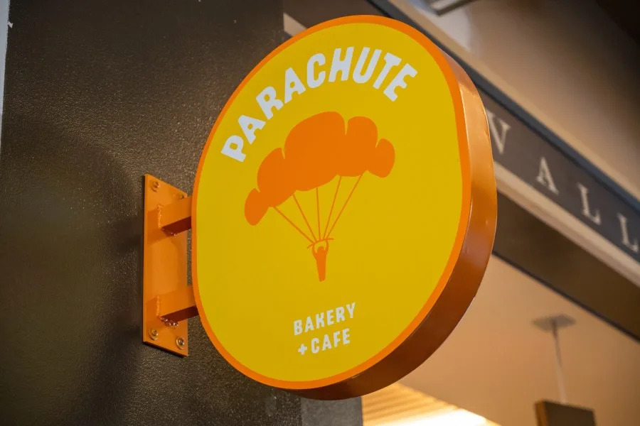 Round Parachute Bakery + Cafe hanging sign with parachute logo in orange and yellow at Ferry Building Marketplace, San Francisco, California, September 18, 2025. (Photo by Smith Collection/Gado/Getty Images)