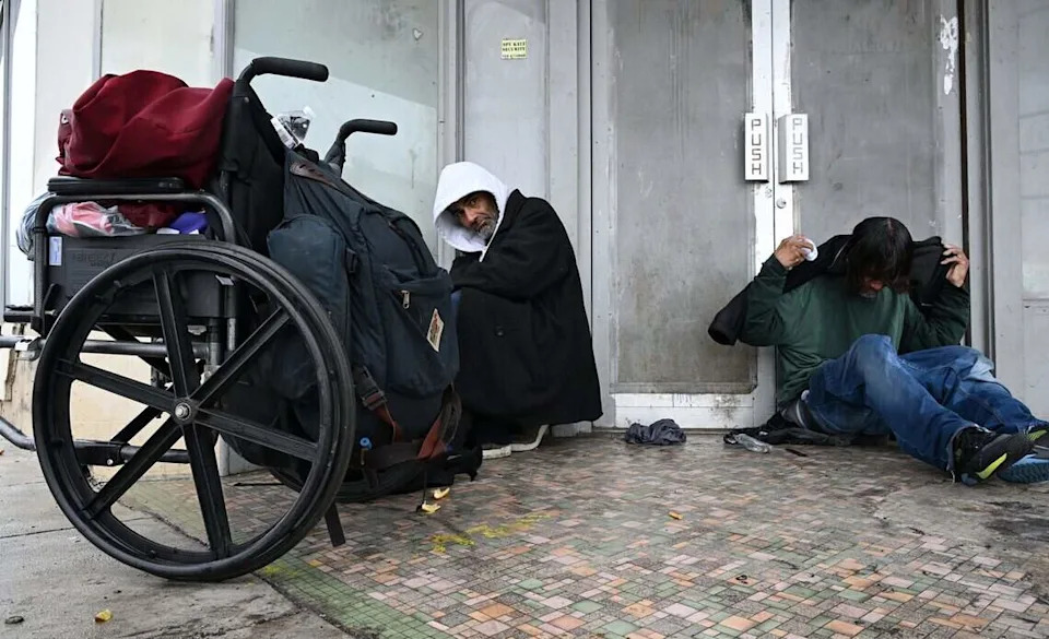 Two homeless men take shelter from the rain in a doorway in Fresno's Chinatown Wednesday morning, Dec 24, 2025 in Fresno.