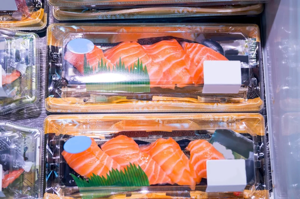 Various sushi and sashimi ready to eat in plastic box package.