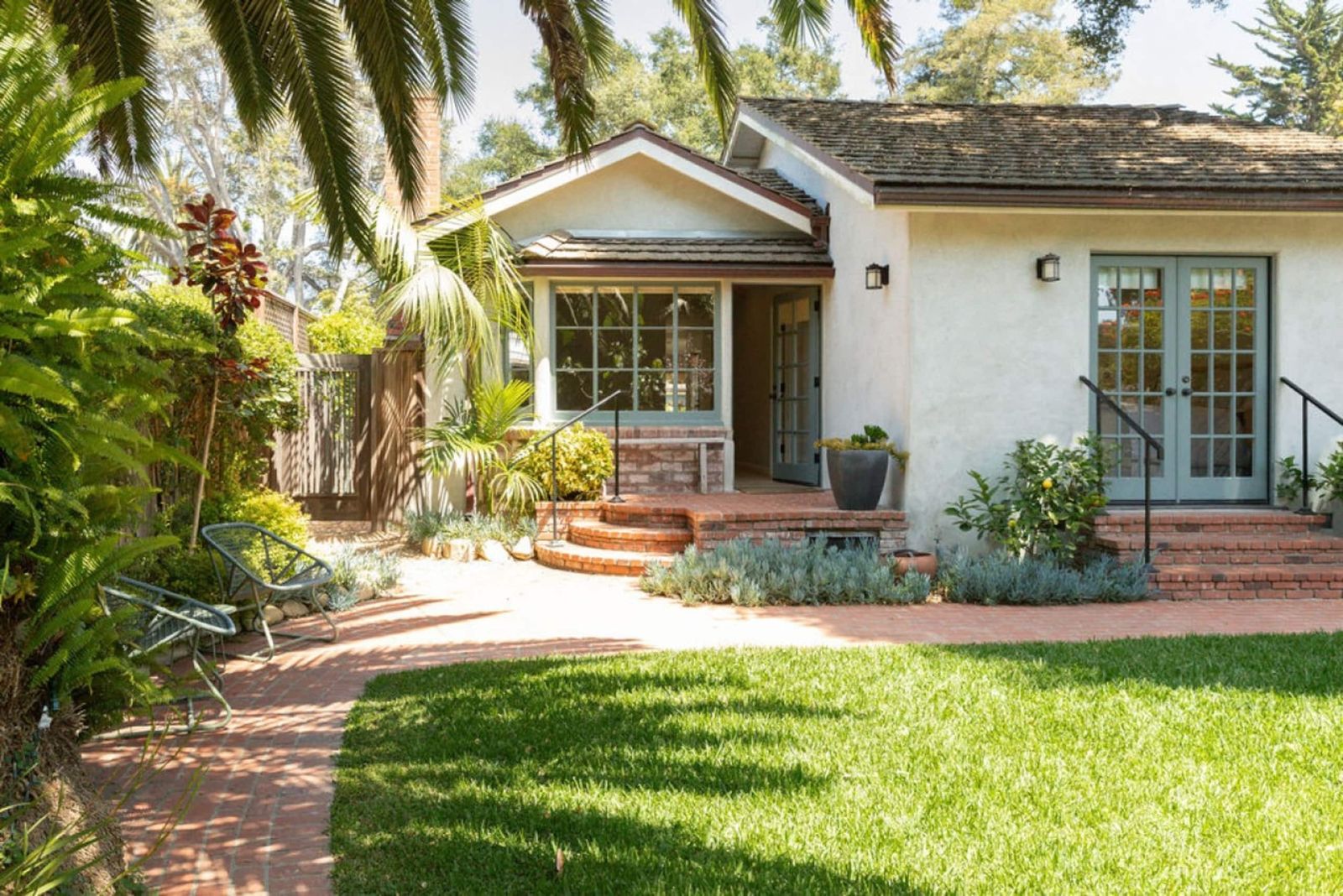 Image may contain Grass Plant Architecture Building House Housing Villa Lamp Door Portico Vegetation and Hotel