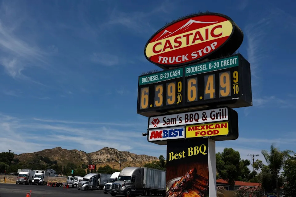 Trucks sit parked by a sign displaying bio-diesel prices over $6 a gallon. Getty Images