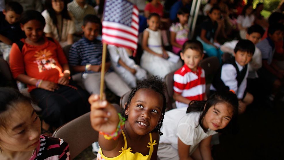 FILE - Six-year-old Rahel Williams holds up a United States flag during a ceremony where she and 24 other children became U.S. citizens at the Sully Historic Site May 21, 2010, in Chantilly, Virginia. (Photo by Chip Somodevilla/Getty Images)