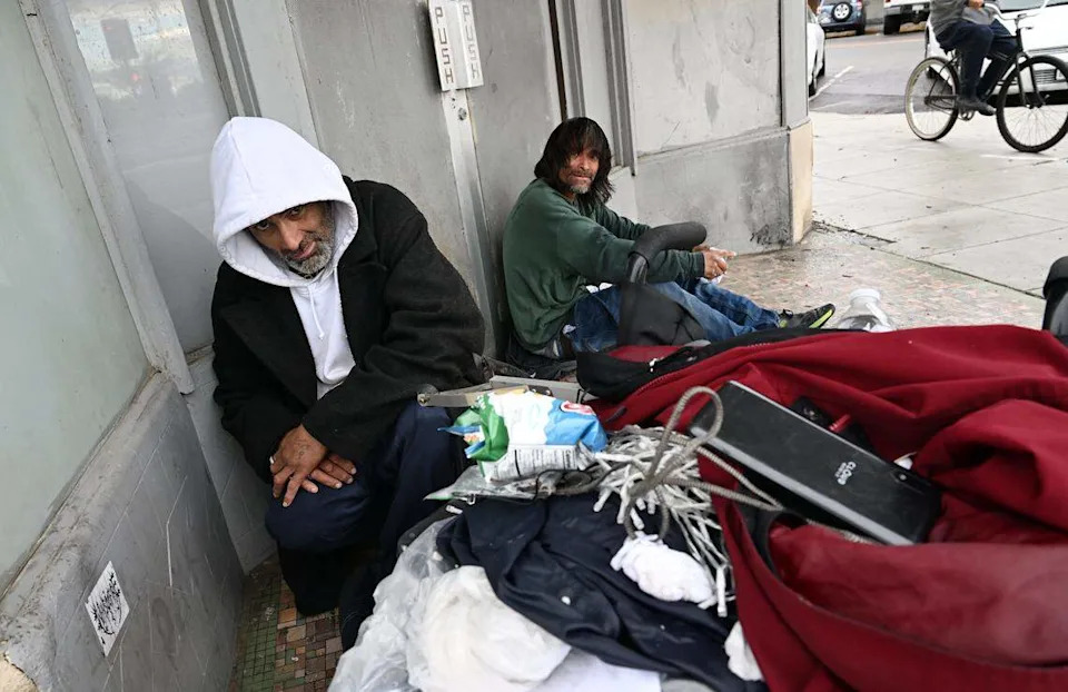 Two homeless men take shelter from the rain in a doorway in Fresno's Chinatown Wednesday morning, Dec 24, 2025 in Fresno.