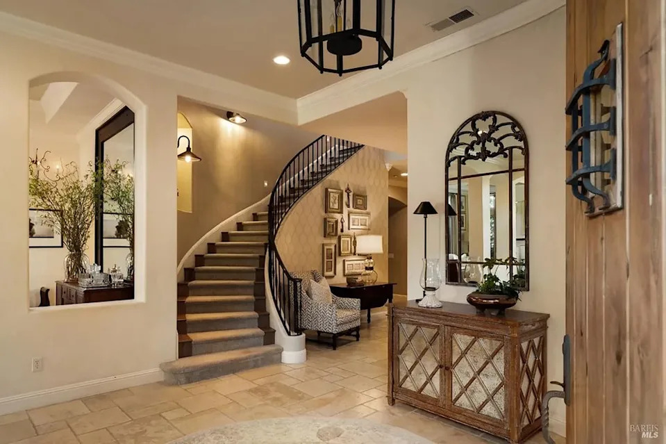 Grand home entry foyer with a sweeping curved staircase and elegant decor