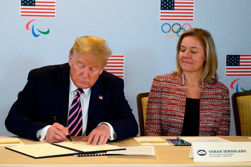 U.S. President Donald Trump signs a document pledging federal support to the Olympics beside U.S. Olympic & Paralympic Committee CEO Sarah Hirshland, on February 18, 2020, in Beverly Hills, California.