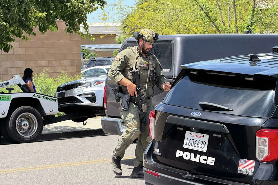A law enforcement officer responds near a bank where a man barricaded himself on Tuesday, June 2, 2026, in Bakersfield, Calif. (Jacob, Dad's Gone Live/Associated Press)