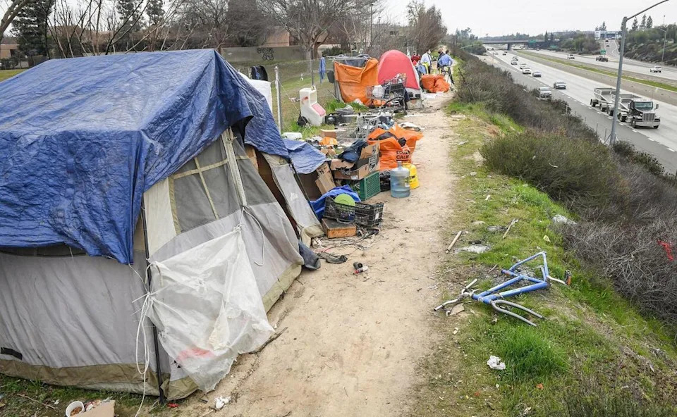 A homeless encampment sits along Highway 41 near Bullard Avenue in north Fresno in this February 2021 file photo.