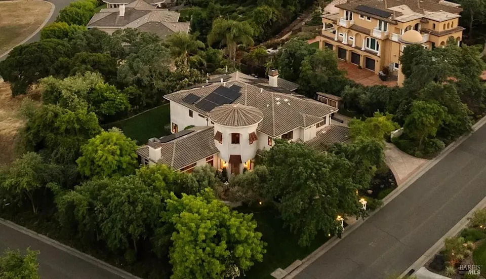 Aerial view of a luxury estate surrounded by lush green trees
