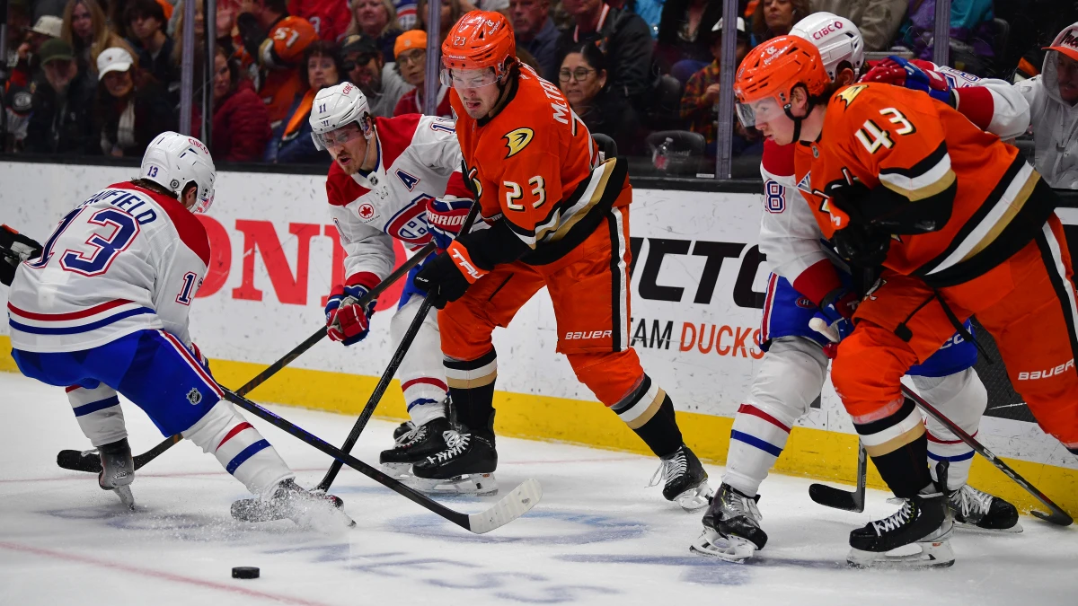 Anaheim, California, USA;Anaheim Ducks center Mason McTavish (23) and defenseman Drew Helleson (43) play for the puck against Montreal Canadiens right wing Cole Caufield (13) and right wing Brendan Gallagher (11) during the third period at Honda Center.