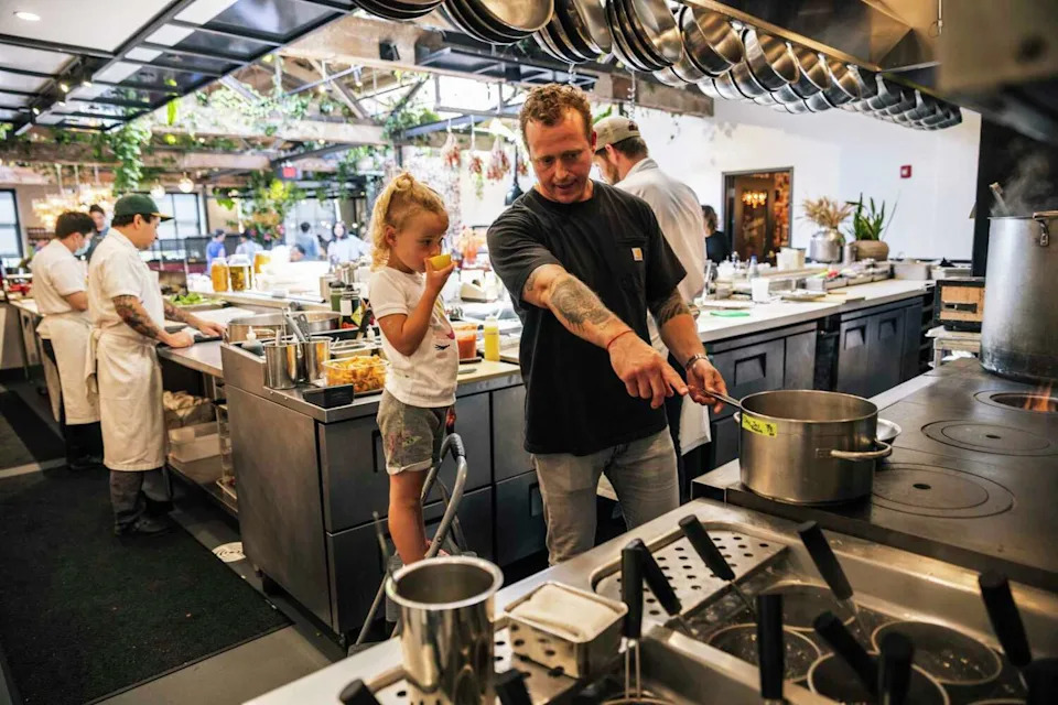 David Nayfeld, co-owner and executive chef at Che Fico, and daughter Helena are seen in the kitchen before dinner service in 2022. (Stephen Lam/The Chronicle)