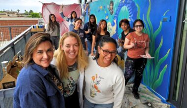 Painters from Warner Middle School and Westminster High School pose for a photo while working on a mural depicting the ecosystems of the Bolsa Chica Wetlands.