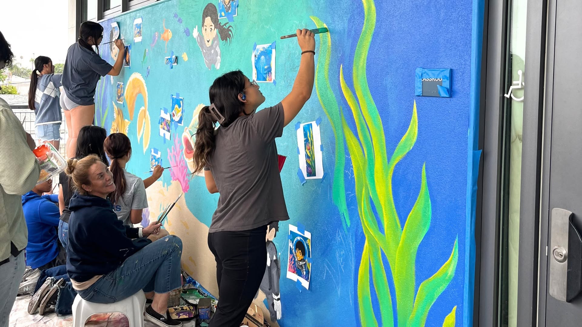 Students collaborate on a mural inspired by the Bolsa Chica Wetlands at Warner Middle School. The project brought together students from Warner Middle School and Westminster High School.