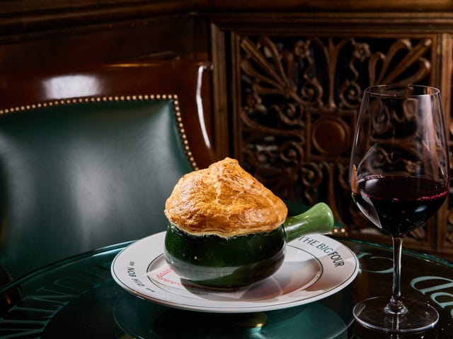 Puff pastry-topped dish with a glass of red wine on a table. Puff pastry-topped dish with a glass of red wine on a table.