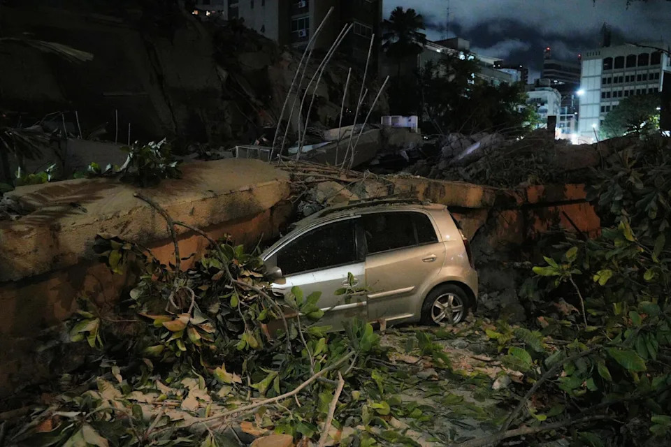 A car was smashed beneath a building that collapsed in the shaking in Caracas.
