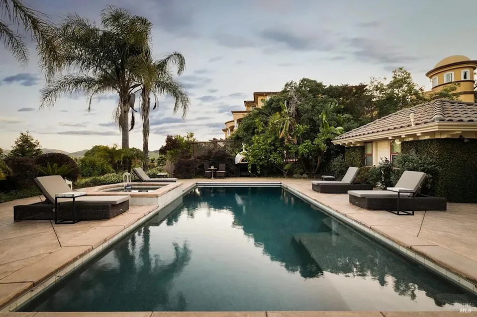 Luxury backyard swimming pool with lounge chairs and a pool house