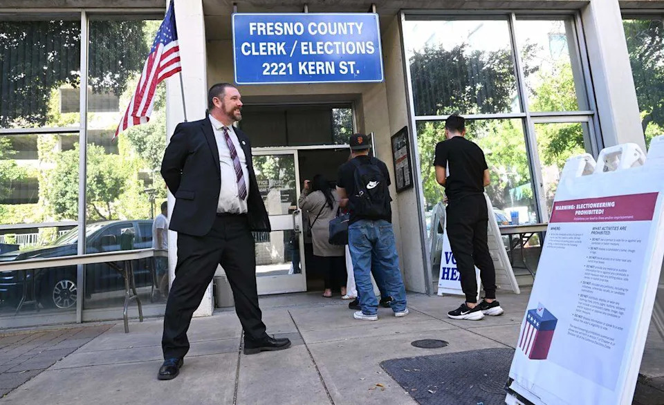 James A. Kus, Fresno County Clerk and Registrar of Voters, left, stands outside observing voters arrive on Election Day Tuesday, June 2, 2026 in downtown Fresno.
