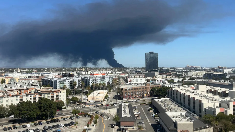 Black smoke rises from a warehouse fire in Boyle Heights as seen from downtown Los Angeles on June 17, 2026. The Los Angeles Fire Department issued a shelter-in-place order for Boyle Heights due to Hazardous materials after a fire at a storage facility which caused a large cloud of black smoke to be released into the air.