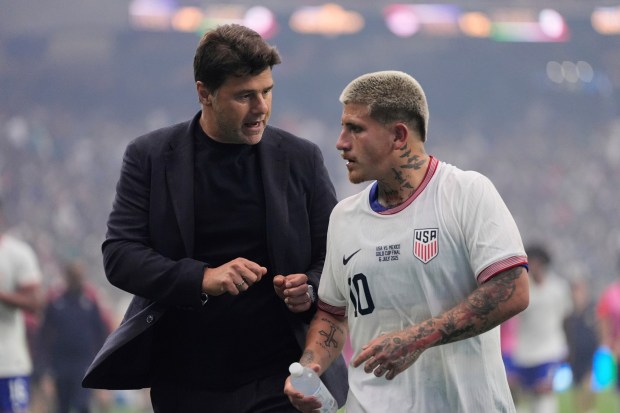 File photo of United States Men's National Soccer team coach Mauricio Pochettino, left, talking with midfielder Diego Luna (10) during a match last summer.ASHLEY LANDIS / AP