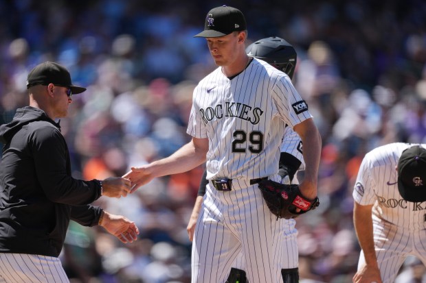 Colorado Rockies manager Warren Schaeffer, left, takes the ball from starting pitcher Tanner Gordon (29) who is pulled form the mound after hitting San Francisco Giants' Daniel Susac with a pitch in the fourth inning of a baseball game Sunday, May 31, 2026, in Denver. (AP Photo/David Zalubowski)