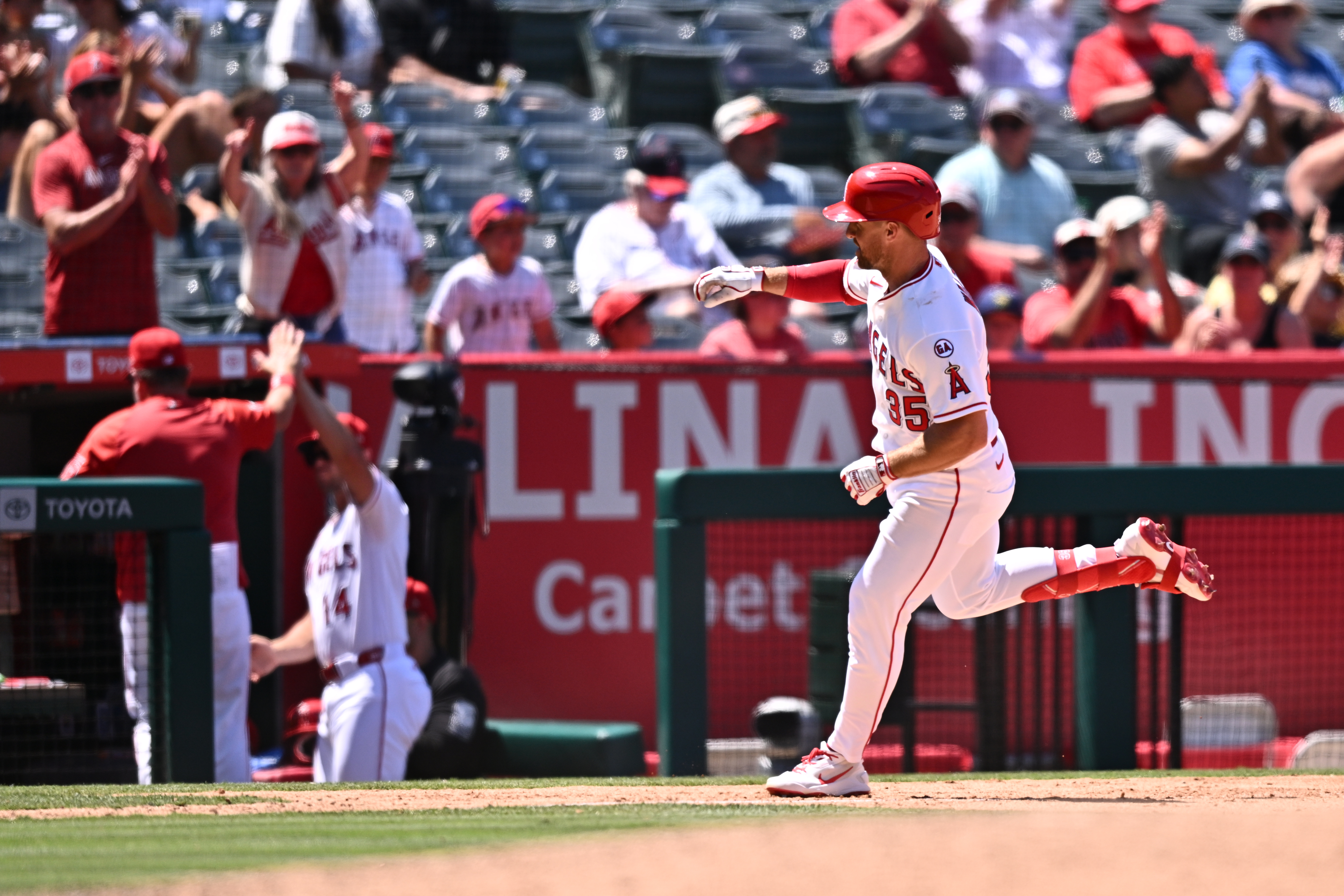 Angels’ Donovan Walton, right, gestures after hitting a home run...