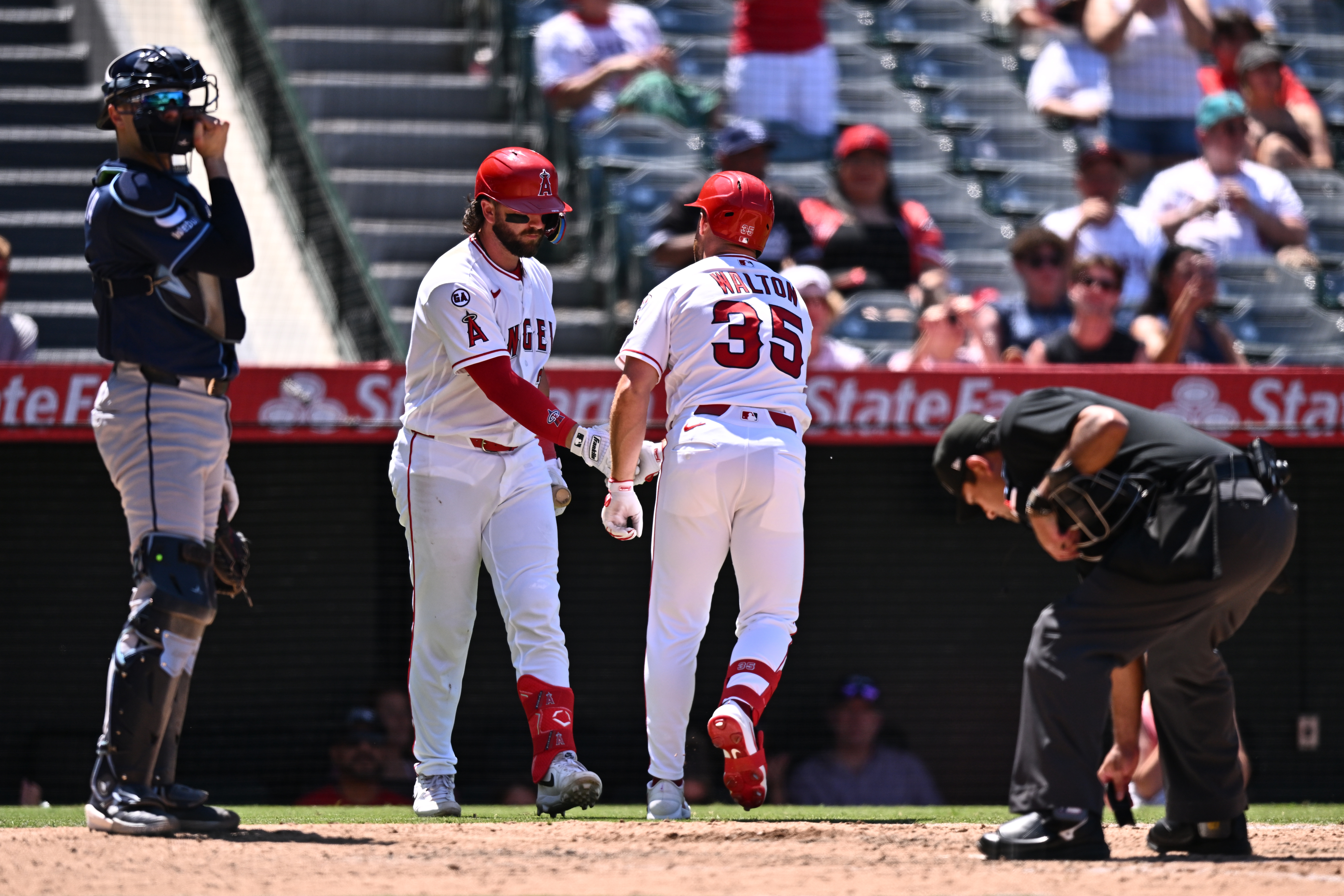 Angels’ Donovan Walton (35) is greeted by Logan Porter, second...