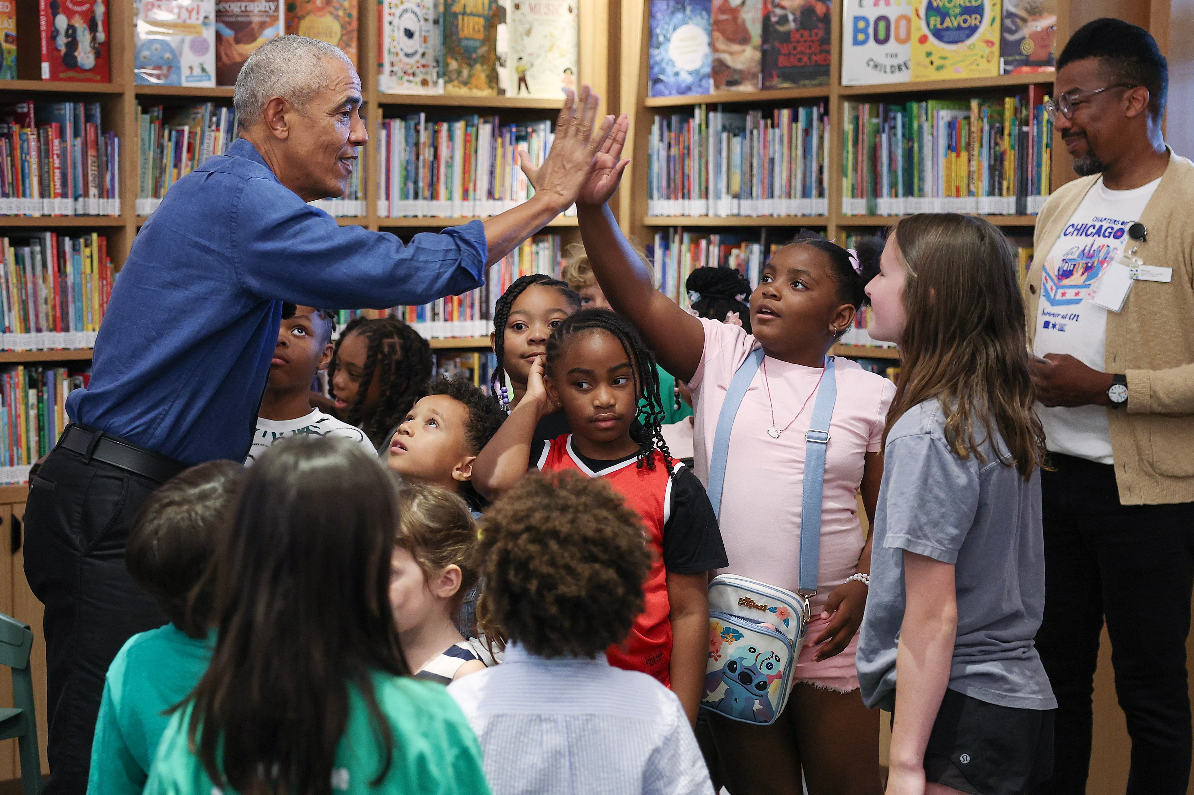 Former President Barack Obama gives a high-five during a book...
