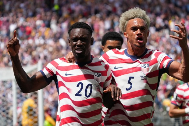 Folarin Balogun (20) and Antonee Robinson (5) celebrate after an early own goal by Australia's Cameron Burgess in their World Cup match in Seattle on Friday. (AP Photo/Ted S. Warren)
