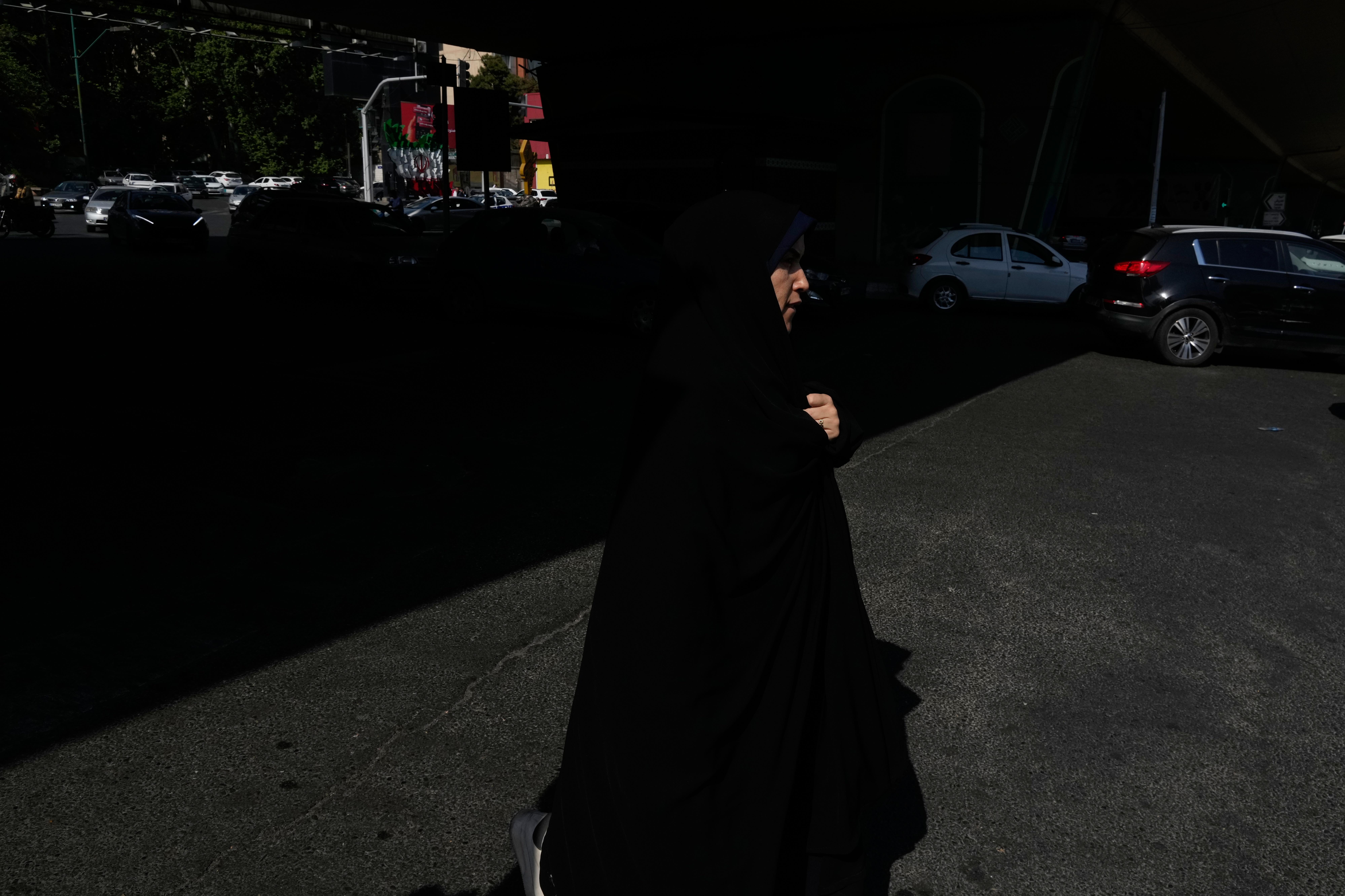 A woman crosses an intersection in northern Tehran.