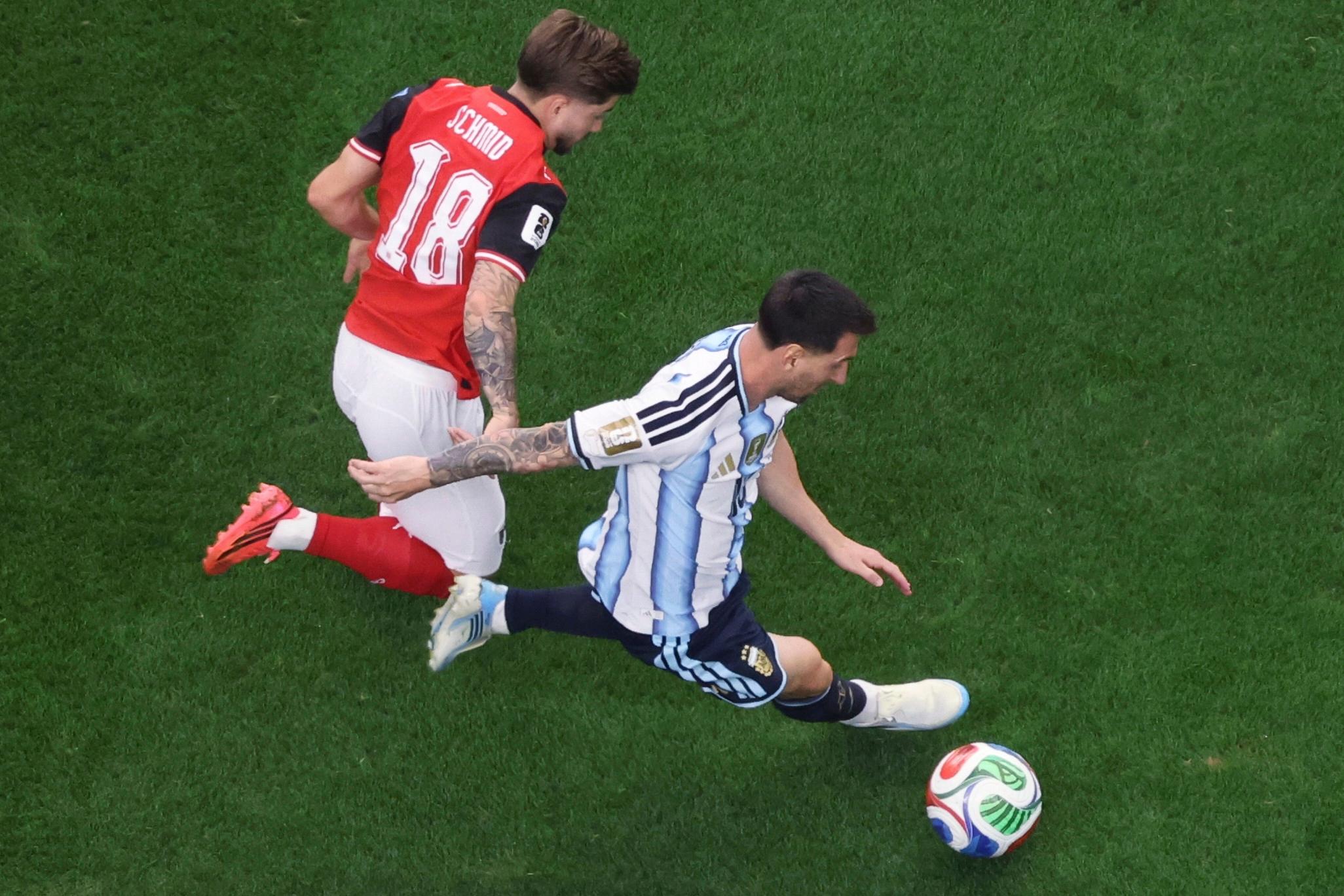 Argentina’s Lionel Messi (10) controls the ball while being pursued...