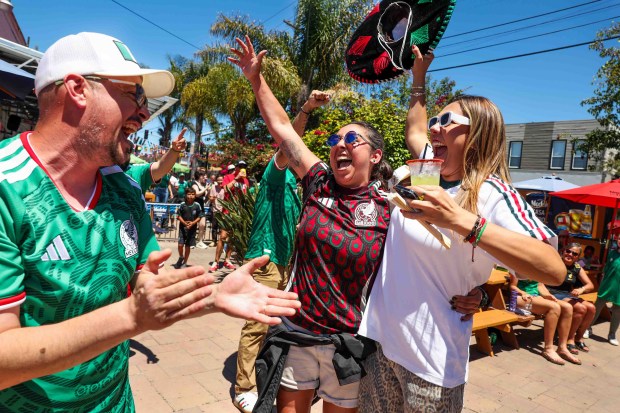 Mexican fans Luis Del Toro, left, of Oakland 68 club, Ana Rivera, of Oakland, and Melissa Castro, of Brentwood, celebrate Mexico's first goal against South Africa at the Aloha Club in the Fruitvale district of Oakland, Calif., on Thursday, June 11, 2026, during a live broadcast of the World Cup inaugural match in Mexico City. (Ray Chavez/Bay Area News Group)