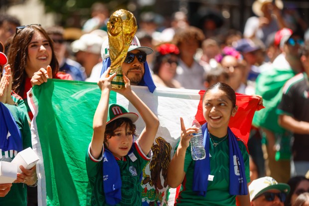 Santiago Gutierrez, 10, holds a World Cup replica trophy with his family Melany Gutierrez, right, and Mario Gutierrez, behind him holding the Mexican Flag, during a watch party for the World Cup game between Mexico and South Africa at San Pedro Square Market in San Jose, Calif., on Thursday, June 11, 2026. (Shae Hammond/Bay Area News Group)