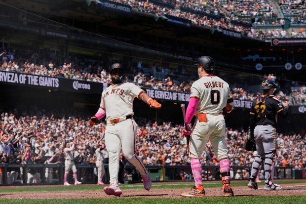 San Francisco Giants' Heliot Ramos, left, celebrates with Drew Gilbert (0) after scoring against the Pittsburgh Pirates on Matt Chapman's double during the sixth inning of a baseball game Sunday, May 10, 2026, in San Francisco. (AP Photo/Godofredo A. Vásquez)