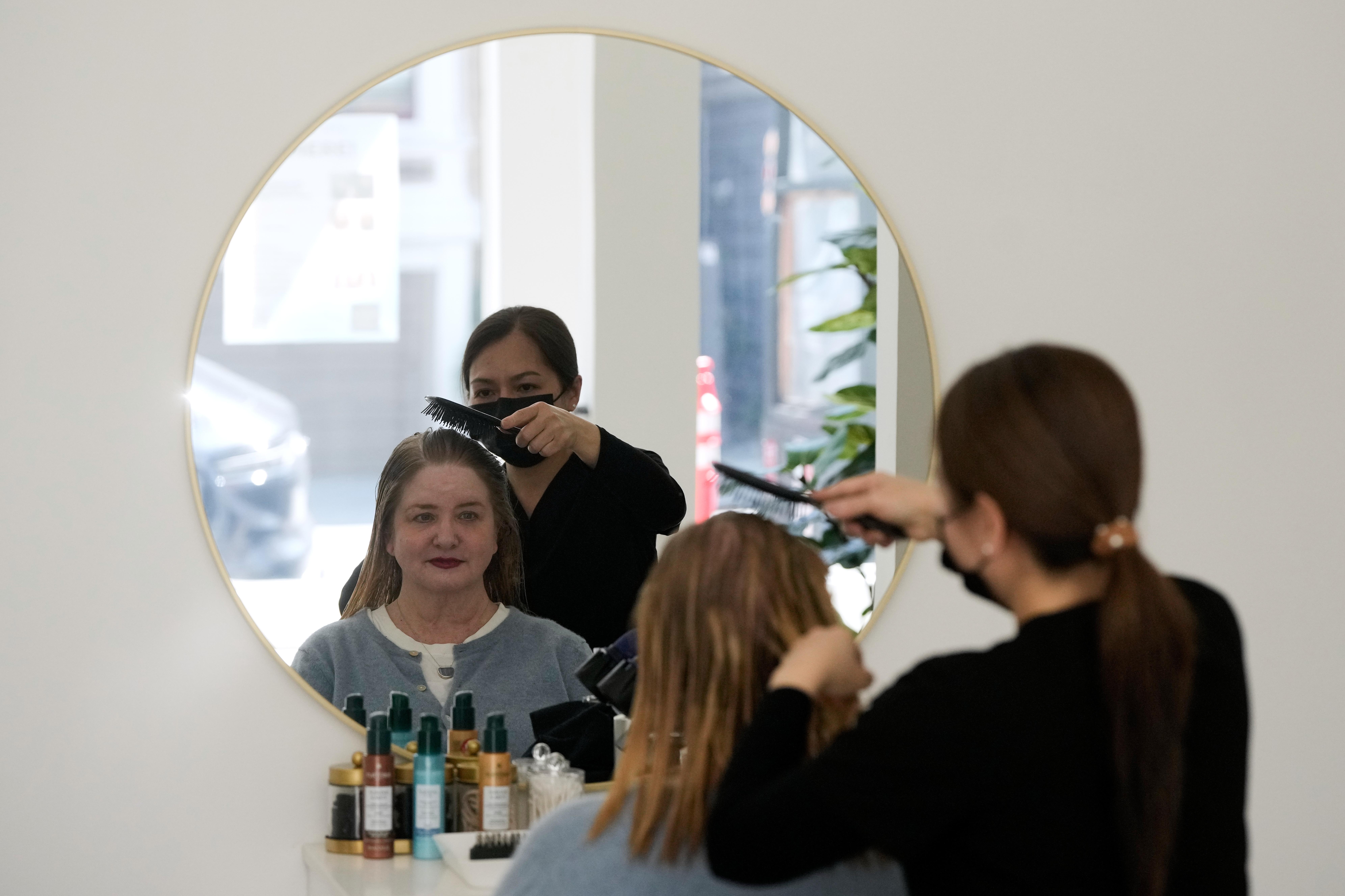 Head spa specialist Ha Truong, right, uses a Red and...